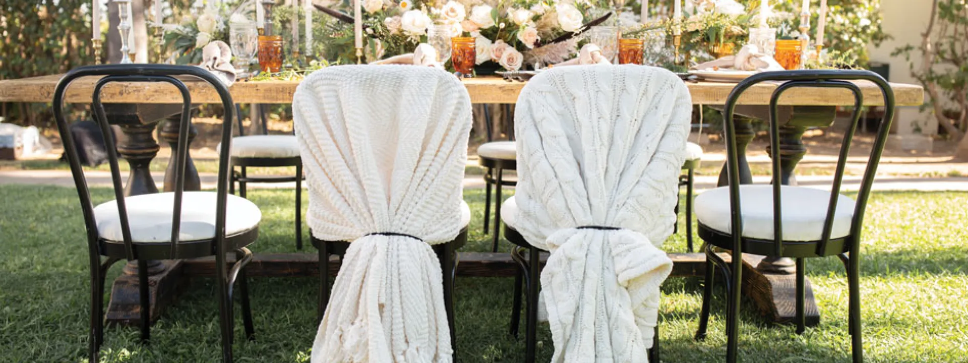 The bride’s and groom’s chairs are wrapped in hygge cable-knit blankets.